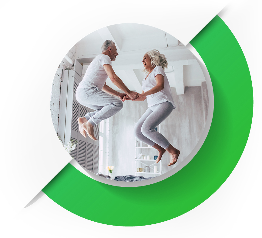 תמונה של זוג פנסיונרים שמחים קופצים על המיטה